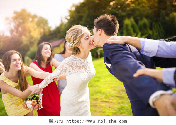 有趣的新婚情侣接吻 伴娘和伴郎在绿色阳光公园幸福婚姻情侣幸福情侣幸福的人